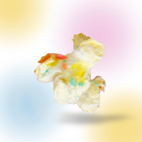 White popcorn pieces coated with yellow, pink, and teal sprinkles against a gradient pastel background.
